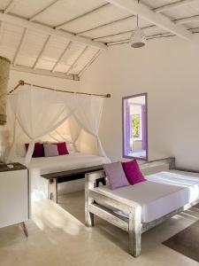 1 dormitorio con 2 camas, sofá y espejo en Pousada Lagoa, en Caraíva