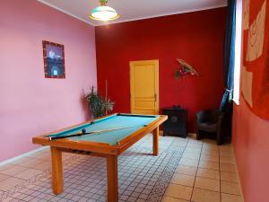 a pool table in a room with a red wall at Gîte Carelles, 5 pièces, 11 personnes - FR-1-600-57 in Carelles
