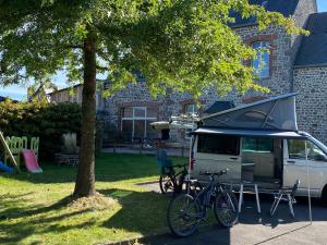 a bike parked next to a car with a camper at Gîte Carelles, 5 pièces, 11 personnes - FR-1-600-57 in Carelles