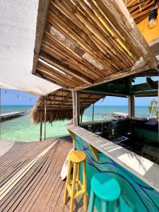 - un bar avec deux tabourets sur une terrasse donnant sur la plage dans l'établissement el arca, à Carthagène des Indes