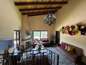 - un salon avec une table et un lustre dans l'établissement Cabaña No.3 Puerta del Bosque Mazamitla., à Mazamitla