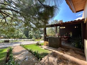 Cette maison dispose d'une terrasse avec une table dans la cour. dans l'établissement Cabaña No.3 Puerta del Bosque Mazamitla., à Mazamitla