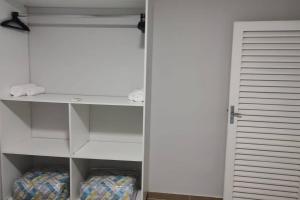 a closet with a white door and a white shelf at Wana casa 4 -Requinte e Conforto in Sao Jose do Rio Preto