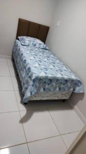 a bed with a blue comforter sitting on a floor at Wana casa 4 -Requinte e Conforto in Sao Jose do Rio Preto