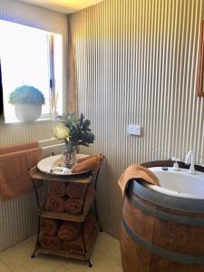 a bathroom with a barrel sink and a tub at Gorgeous Country Woolshed in Loomberah