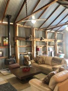 a living room with a couch and a table at Gorgeous Country Woolshed in Loomberah