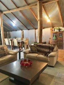 a living room with two couches and a coffee table at Gorgeous Country Woolshed in Loomberah