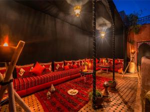 a living room with a red couch in a tent at Riad Irhalne in Marrakesh