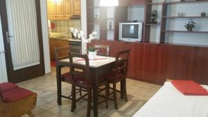 a kitchen with a table and chairs and a tv at Apartments by the sea Bakarac, Kraljevica - 21710 in Bakarac