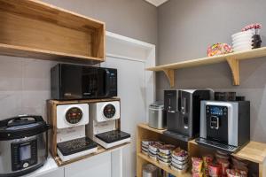 una cocina con varios microondas y electrodomésticos en estanterías en Hey Gunsan Hotel en Gunsan