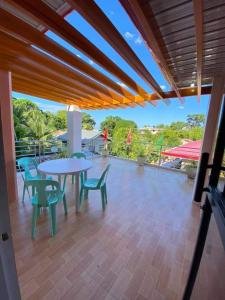 a patio with a table and chairs on a deck at La Fela Pension House in Oslob