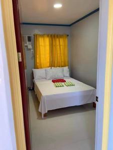 una camera con letto bianco con tenda gialla di La Fela Pension House a Oslob