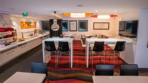 a room with a table and chairs and a kitchen at Holiday Inn Express Dijon, an IHG Hotel in Dijon