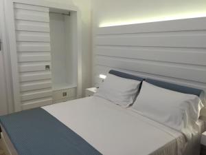 a white bed with a blue headboard in a bedroom at Villa il Barone in Tropea