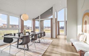 a dining room with a table and chairs and windows at 4 Bedroom Cozy Home In Hadsund in Hadsund