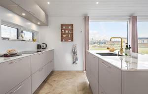 a kitchen with white cabinets and a large window at 4 Bedroom Cozy Home In Hadsund in Hadsund