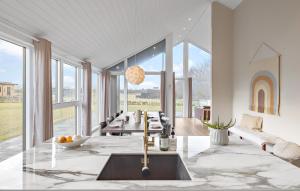 a living room with a table and chairs and windows at 4 Bedroom Cozy Home In Hadsund in Hadsund +20 photos