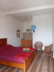 um quarto com uma cama com lençóis roxos e uma cadeira em Hazza syaria homestay em Garut