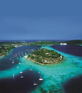 an island in the ocean with boats in the water at Iririki Island Resort & Spa in Port Vila