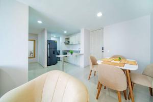 cocina y comedor con mesa y sillas en Modern and Cozy apartment, en Sabaneta