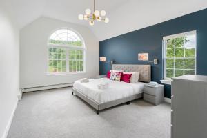 a bedroom with a large bed and two windows at Malkita’s Mountain View Villa in Woodbury