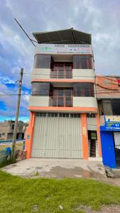 un edificio alto con una naranja y blanco en CASA HOSPEDAJE LAS MONTAÑAS, en Huancayo