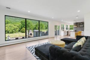 a living room with black furniture and large windows at Malkita Aria Mountainview Retreat in Woodbury