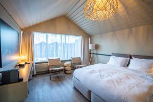a bedroom with a large bed and a large window at The Hill Hotel at Flúðir in Fludir