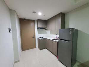 a small kitchen with a refrigerator in a room at Luxurious Flat 2BR in Gold Coast PIK Penjaringan in Jakarta