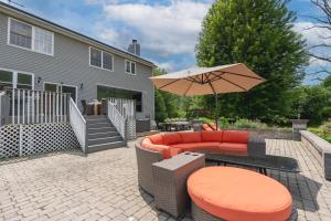 a patio with a couch and an umbrella and a table at Malkita Aria Mountainview Retreat in Woodbury