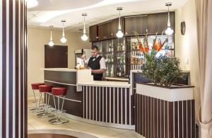 a man standing at a bar in a restaurant at Hotel Justyna in Kraków