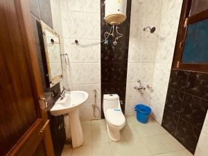 La salle de bains est pourvue de toilettes et d'un lavabo. dans l'établissement The Aston Hills - A Luxury Stay , Shimla, à Shimla