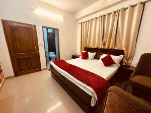 sypialnia z łóżkiem z czerwonymi poduszkami i oknem w obiekcie The Aston Hills - A Luxury Stay , Shimla w mieście Shimla