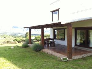 Cette maison blanche dispose d'une terrasse avec une table de pique-nique. dans l'établissement La Escondida Tafi del Valle, à Tafí del Valle
