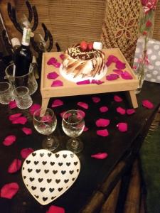 una mesa con un pastel y corazones rosados en ella en Mirador de la Montaña Glamping en San Francisco