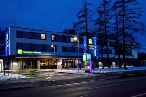 ein Gebäude am Straßenrand in der Nacht in der Unterkunft Holiday Inn Express Munich - Olympiapark, an IHG Hotel in München