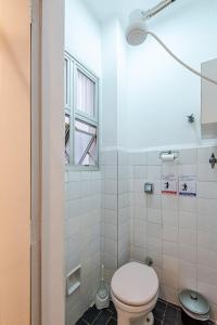 uma casa de banho com um WC e uma janela em Apê Clássico e Aconchegante no Guarujá - 350 m da praia no Guarujá