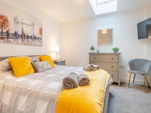 a bedroom with a bed with a dog laying on it at Walcot House Stables in Diss