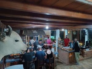 a group of people standing around a bar with a cow head at River Song's Hotel in Mindo