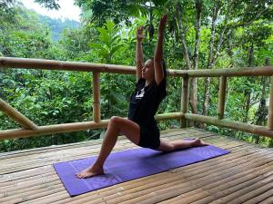 een vrouw die een yoga pose doet op een yoga mat bij River Song's Hotel in Mindo