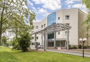 a large white building with a glass facade at Hotel Justyna in Kraków