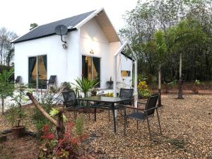 a small white house with a table and chairs at ที่พักฮิมฝายบึงกาฬ 