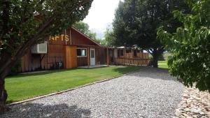 a house with a gravel driveway in front of it at Blue Mountain RV Park in Blanding