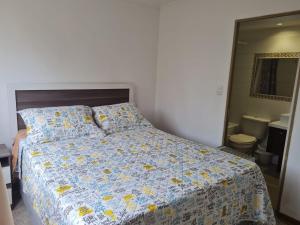 - une chambre avec un lit doté d'une couette et d'oreillers dans l'établissement Portal, à La Serena