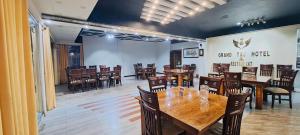 a dining room with wooden tables and chairs at Grand Taj in Murree