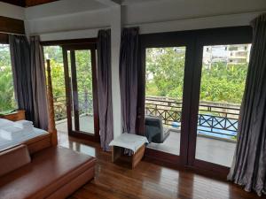 a bedroom with a bed and a balcony with sliding glass doors at Thao’s Villa in Ho Chi Minh City