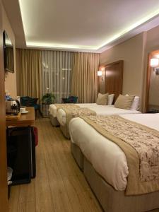 a hotel room with three beds and a desk at İstport Hotels in Arnavutköy