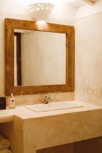 een badkamer met een wastafel en een spiegel bij Pousada Lagoa in Caraíva