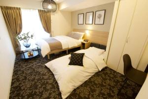 東京にあるノール下丸子305のベッド2台と窓が備わるホテルルームです。