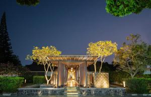 un pavillon avec des arbres devant un bâtiment dans l'établissement Loman Park Hotel Yogyakarta, à Yogyakarta